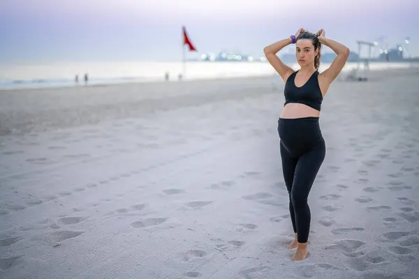 Spor Kıyafetli Genç Hamile Bir Kadın Saçını Bağlıyor Plajda Rahat — Stok fotoğraf