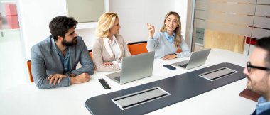 Bir grup iş adamı konferans masasında toplantı yapıyor.