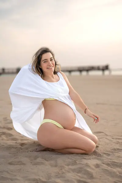 Full Length Portrait Pregnant Young Woman Sitting Beach Showing Her — Stock Photo, Image