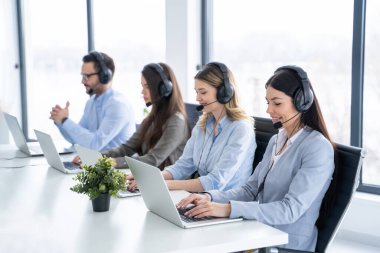 Müşteri destek servisinde çalışan kulaklıklı arkadaş canlısı çağrı merkezi yöneticileri.