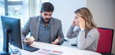 İş çatışması. İş arkadaşları ofiste tartışıp birbirlerine bağırıyorlar. İş kavramında istismar ve çatışma. İş kadını ellerini başının üstüne koyup yüksek sesli amirini dinleyemiyor..