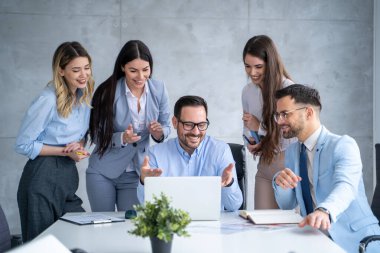 Çıkan bir grup iş adamı, ofisteki bilgisayardan onaylanmış proje hakkında iyi haberler alıyor.