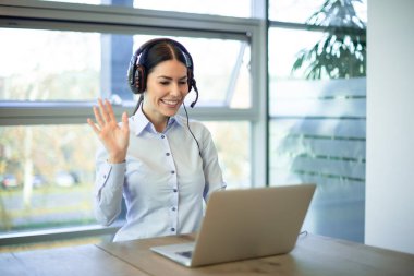 Video çağrısı konsepti. İş kadını iletişim, sanal toplantı ve Girişim şirketinde küresel danışmanlık için kulaklıkla dizüstü bilgisayarını sallıyor..