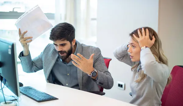 Businessman arguing and yelling at his female colleague in office. Abuse and conflict at work concept. Businesswoman with hands on head cant listen her loud superior. Business conflict.