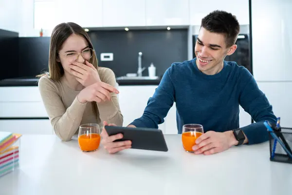 男女青少年在平板电脑上看有趣的视频 在家里笑 — 图库照片