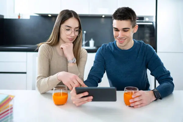 Kadın Erkek Öğrenciler Birlikte Tablet Kullanıyor Evde Meyve Suyu Içiyorlar — Stok fotoğraf