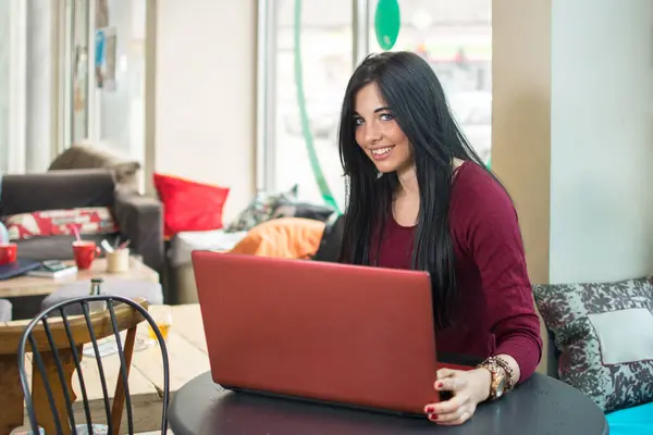Bir Kafede Dizüstü Bilgisayar Kullanan Gülümseyen Genç Bir Kadın — Stok fotoğraf
