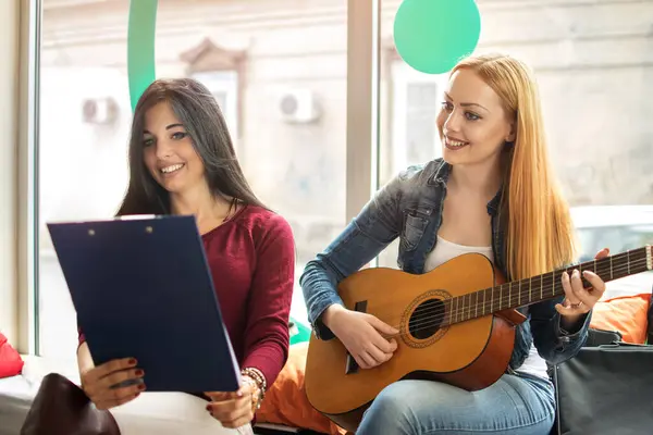 年轻的女性朋友们一边唱歌一边弹吉他 — 图库照片