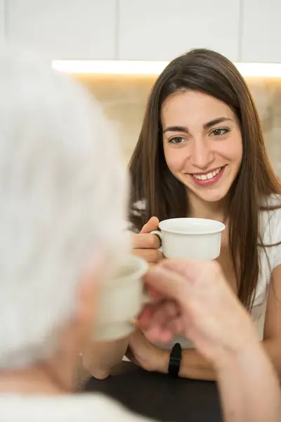在家里和奶奶喝杯咖啡的孙女笑着 — 图库照片