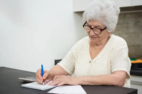Starsza Kobieta Papierami Lub Rachunkami Kalkulatorem Pisząca Domu — Zdjęcie stockowe