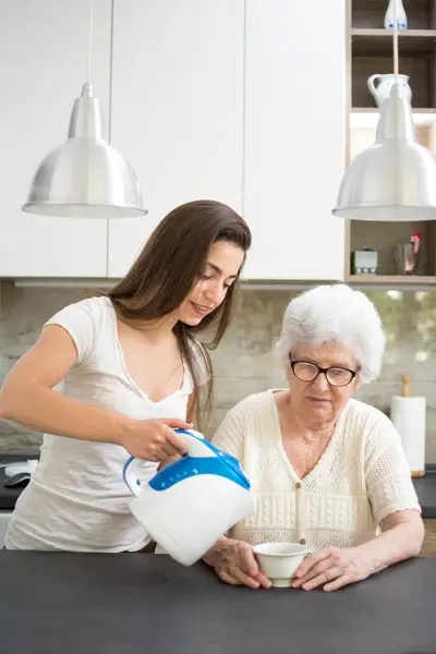 Enkelin Bringt Ihrer Großmutter Eine Tasse Tee — Stockfoto