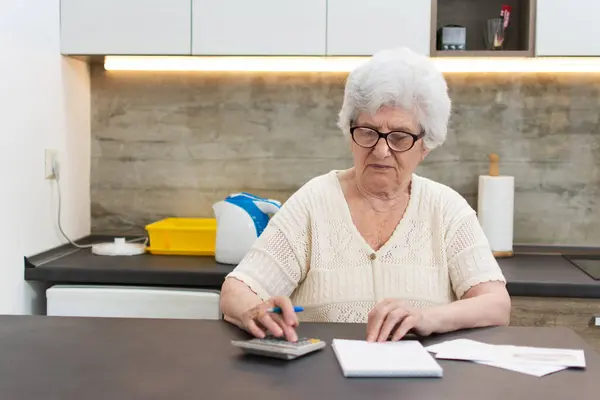 Starsza Kobieta Kalkulatorem Papierami Liczącymi Domu — Zdjęcie stockowe