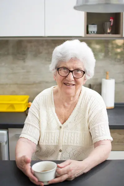 Szczęśliwy Uśmiechnięty Starsza Kobieta Filiżanką Herbaty Lub Kawy Kuchni — Zdjęcie stockowe