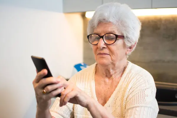 Ευτυχισμένη Ηλικιωμένη Γυναίκα Που Χρησιμοποιεί Smartphone Στο Σπίτι — Φωτογραφία Αρχείου