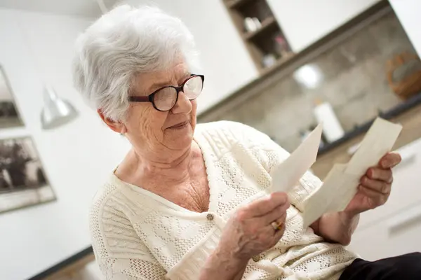 Büyükanne Evde Oturuyor Eski Fotoğraflara Bakıyor — Stok fotoğraf