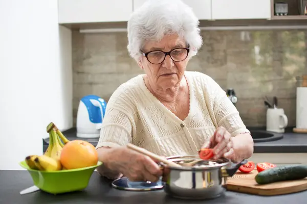 Kıdemli Kadın Mutfakta Sebzeli Bir Yemek Hazırlıyor — Stok fotoğraf