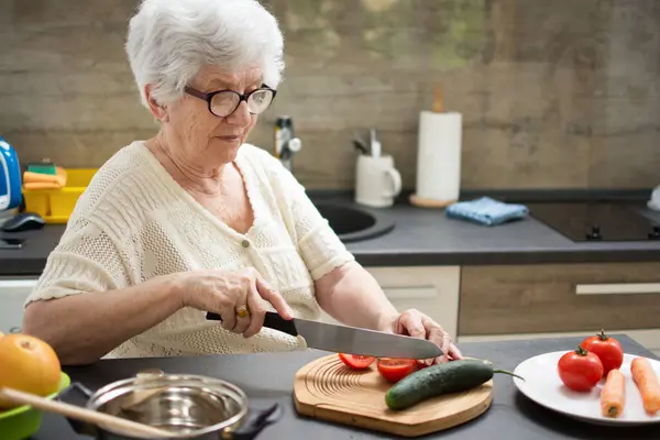 在厨房里用新鲜蔬菜做健康食品的老年妇女 — 图库照片
