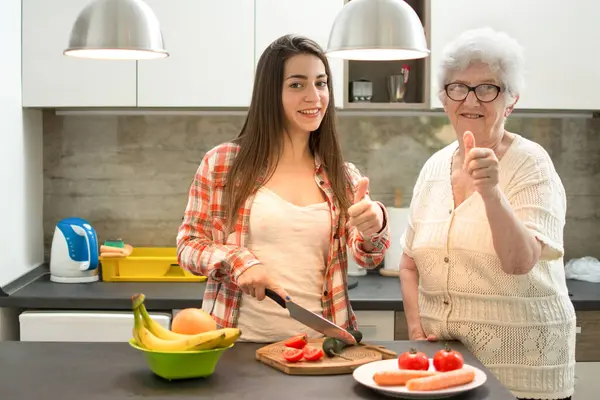 奶奶做饭的孙女 在厨房里竖起大拇指 — 图库照片