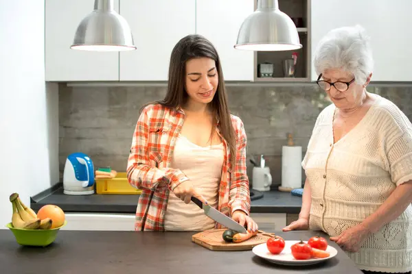 孙女和奶奶在厨房切水果 — 图库照片