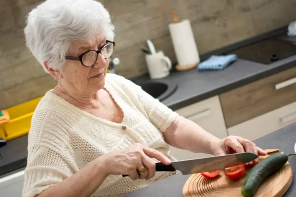 Ηλικιωμένη Γυναίκα Που Κόβει Λαχανικά Στην Κουζίνα — Φωτογραφία Αρχείου