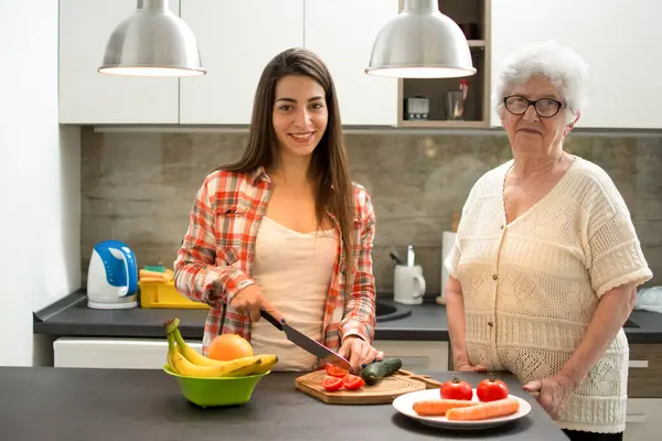 Kleindochter Haar Grootmoeder Staan Keuken Snijden Tomaat — Stockfoto