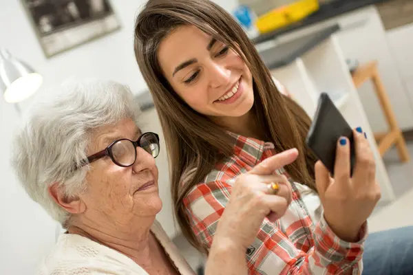 Babička Ukazuje Něco Mobilním Telefonu Své Mladé Vnučce — Stock fotografie