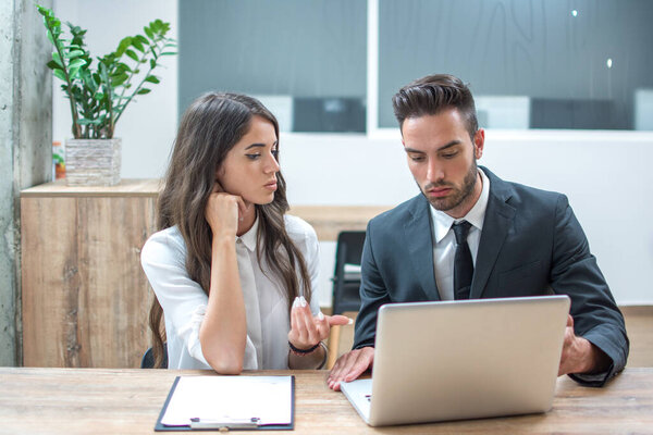 Business woman and man discussing project on laptop in office