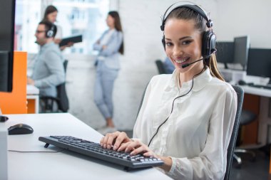 Çağrı merkezinde, müşteri hizmetleri operatörü olarak çalışan arkadaş canlısı genç bir bayan.