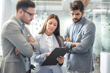 İş adamları ofiste belgeleri tartışıyor