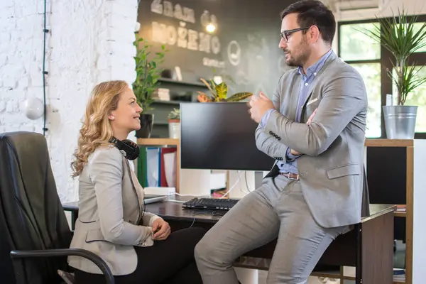 İş arkadaşları ofis molasında konuşuyor. Çekici orta yaşlı kadın ofiste yakışıklı bir erkek arkadaşla konuşuyor..