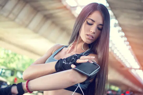 アームバンドでスマートフォンに触れる若い女性の肖像画 — ストック写真