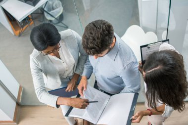 İş adamlarının toplantıda birlikte çalışmalarına, ofiste belgeleri tartışmalarına.