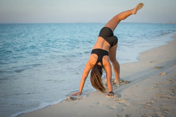 在海滩上锻炼的瘦身女运动员的背影 — 图库照片