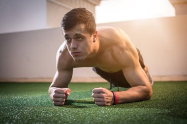 Formda olmayan adam dışarıda kalas egzersizi yapıyor.