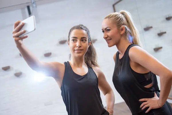 Δύο Σπορ Κορίτσι Λήψη Selfie Φωτογραφία Κινητό Τηλέφωνο Στο Γυμναστήριο — Φωτογραφία Αρχείου