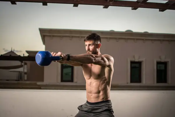Muskulöses Sportlertraining Ohne Hemd Mit Der Kettlebell Auf Dem Dach — Stockfoto