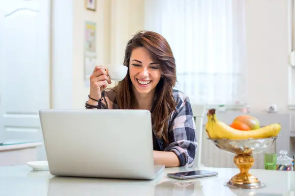 Genç Bir Kadın Dizüstü Bilgisayar Kullanıyor Evde Kahve Fincanı Içiyor — Stok fotoğraf