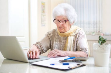 Üst düzey kadın evinde faturaları sayıyor.