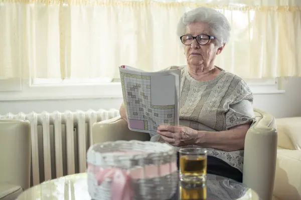 Senior Kvinna Lösa Ett Korsord Hemma — Stockfoto