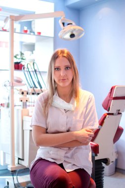 Diş kliniğinde genç bir dişçinin portresi.