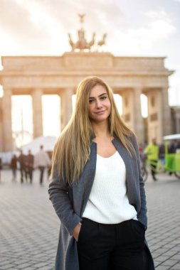 Almanya, Berlin 'de Brandenburg Kapısı önünde duran güzel genç bir kadının portresi.