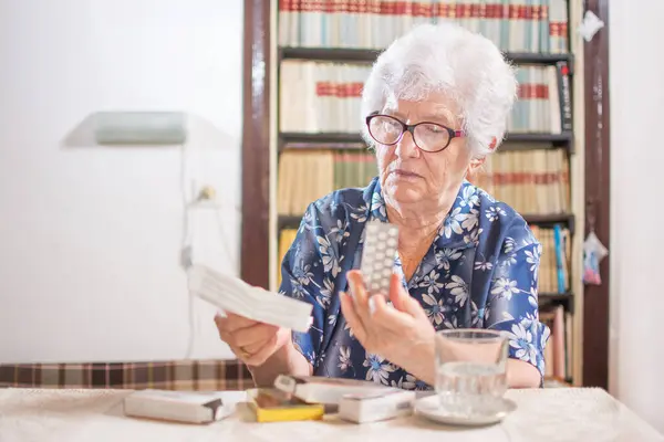 Пожилая Седовласая Женщина Лекарствами Чтение Рецепта Лекарства Дома — стоковое фото