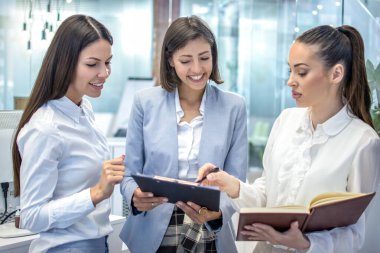 Sözleşme belgeleri üzerinde çalışan genç ve güzel iş kadınları.