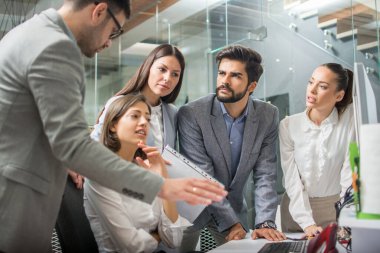 Modern ofiste birlikte çalışan bir grup genç iş adamı.