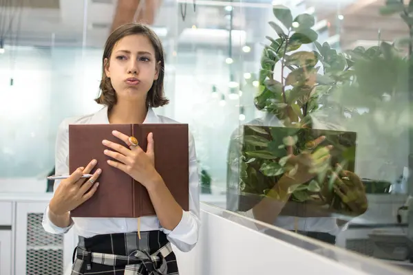 Portrait Beautiful Young Business Woman Pouting Holding Notebook Office — Stock Photo, Image