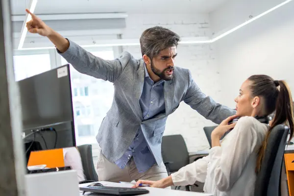 怒っている上司がオフィスの女性従業員を動揺させます 若い男性ビジネスマネージャーは怖がって叫び 職場でビジネス女性を強調しました — ストック写真