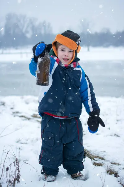 Küçük Çocuk Soğuk Kış Gününde Elinde Cam Bir Şişe Tutuyor — Stok fotoğraf