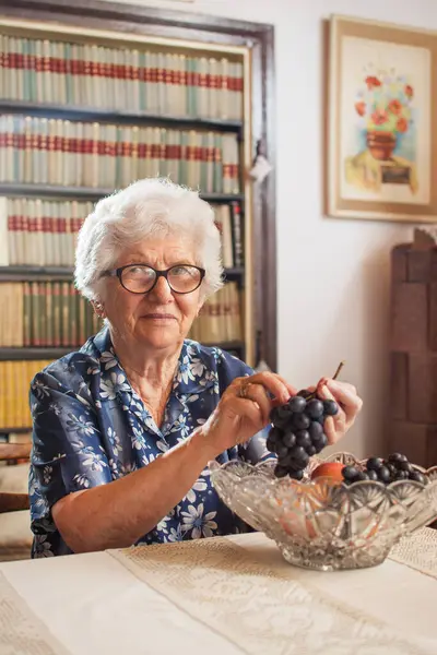 Evde Bir Tabak Üzümlü Mutlu Yaşlı Kadın — Stok fotoğraf