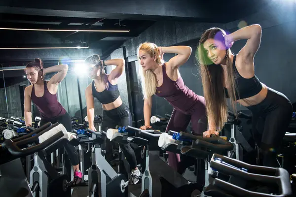 Ομάδα Ελκυστικών Αδύνατων Νεαρών Γυναικών Που Εκπαιδεύονται Ποδήλατα Γυμναστικής Μαζί — Φωτογραφία Αρχείου