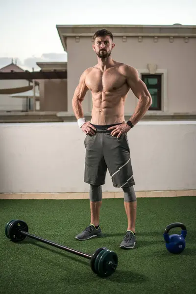 屋外での体重トレーニングの準備をする運動シャツレス男性の完全な長さの肖像画 — ストック写真